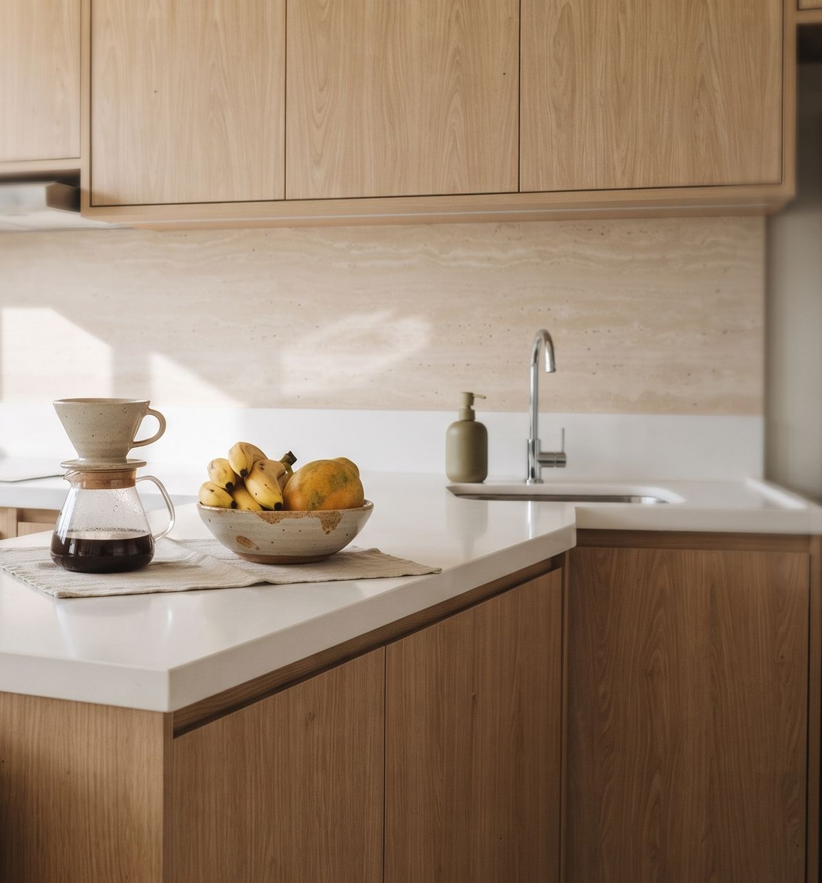 Cozinha com bancada branca, café coado e fruteira