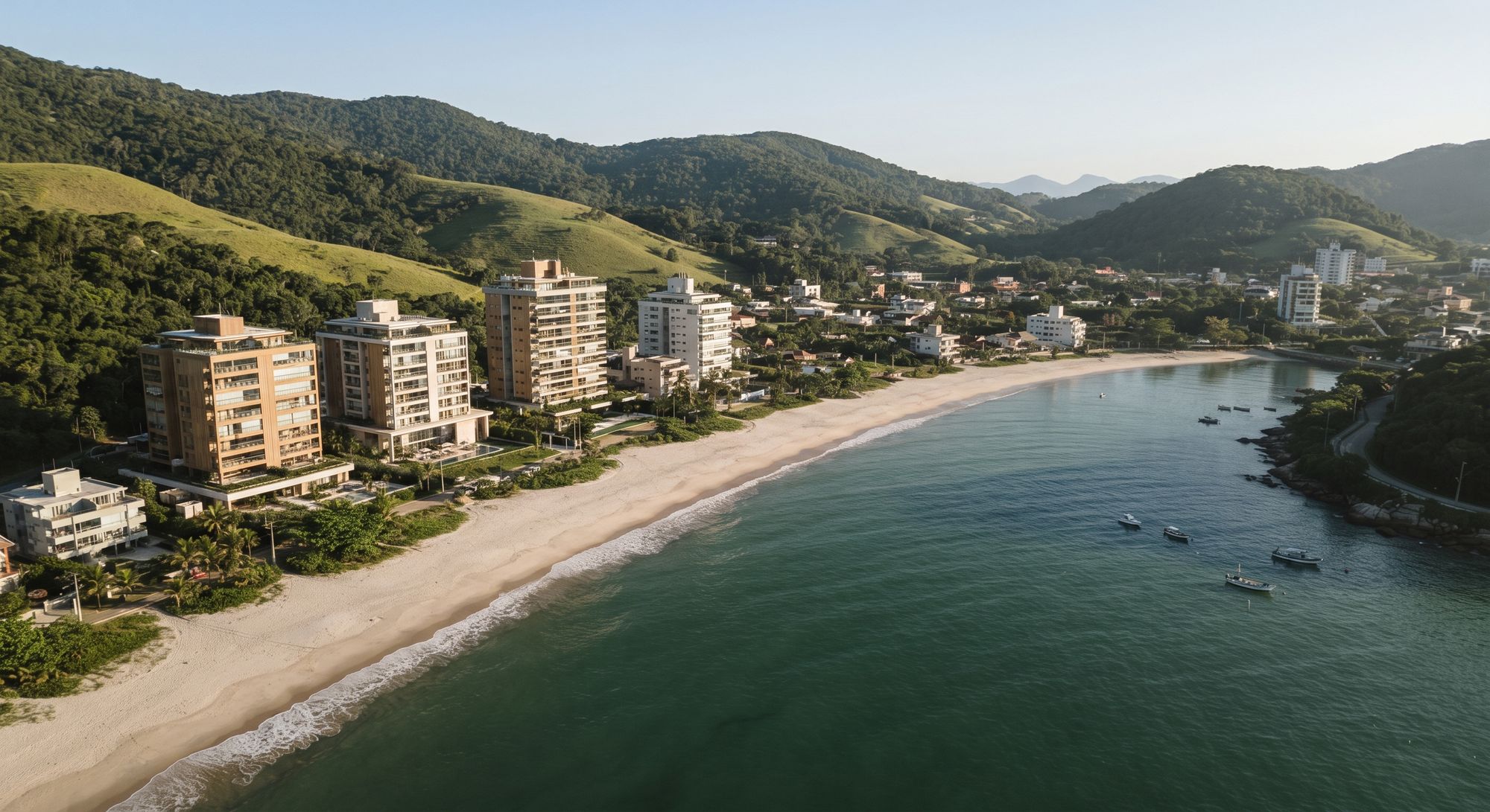 Vista aérea de praia com prédios e morros verdes